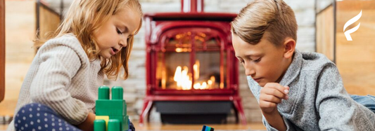 An image of two children sitting in front of a Vermont Castings Radiance Gas Stove
