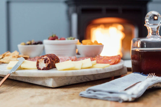 A table setting of food with a fire lit in the background