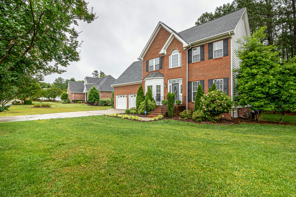Exterior shot of a brick house with green grass