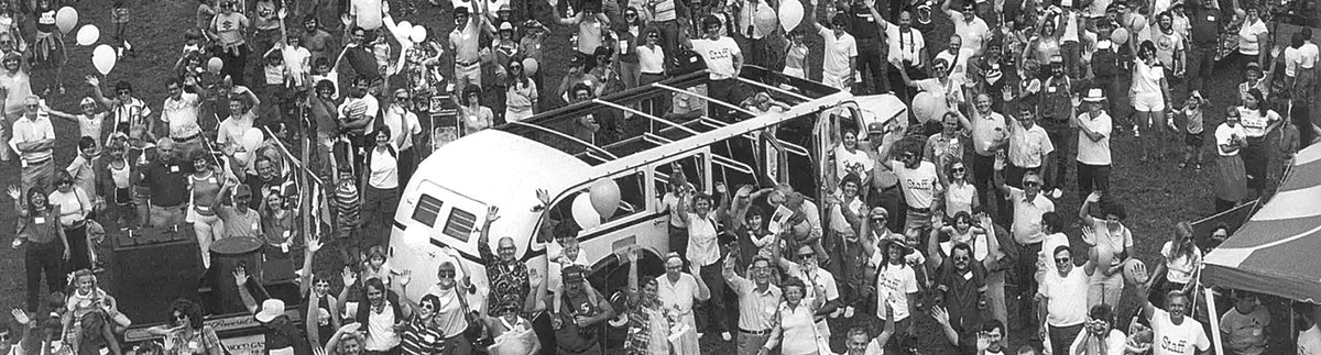 Over head black and white view of a Vermont Castings owners' outing with a wood fired bus in the center of the crowd of people